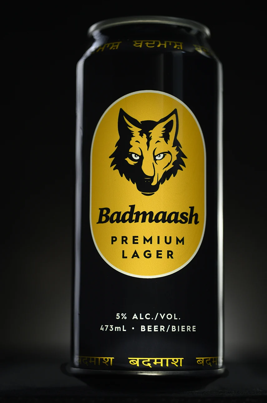 Badmaash Premium Lager can photographed under a single warm light: wolf crest, 5% alc./vol., 473 mL